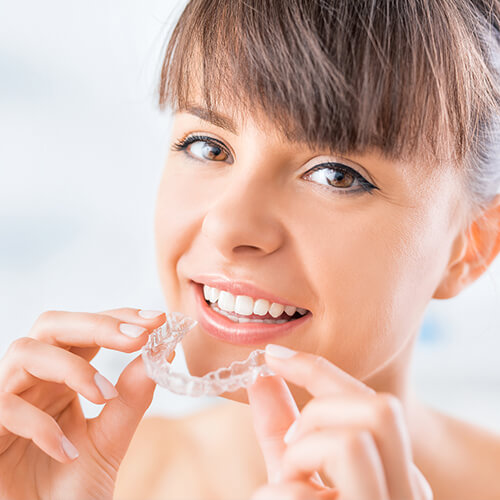Align your smile discreetly with the transparent aligner Woman applying her clear aligners