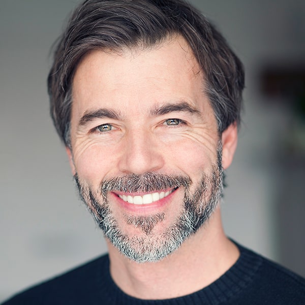 A mature man with dental implants smiling