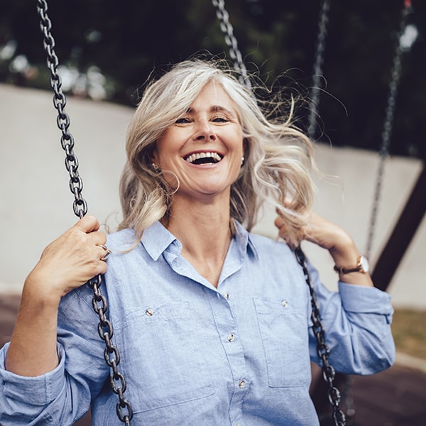 A mature woman having fun using in the swing 