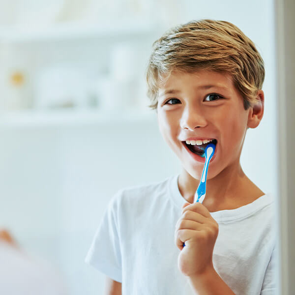 A young boy brushing his teeth.