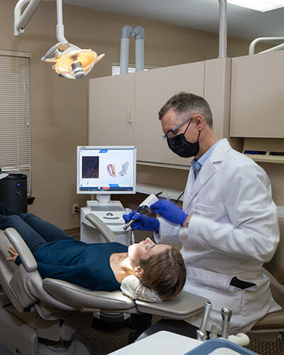 Dr. Alm working in a patient sitting in the dentist's chair